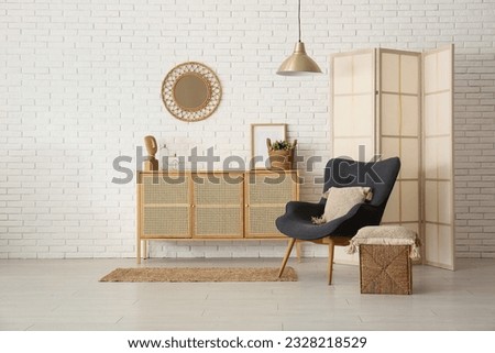 Modern living room interior with black armchair, cabinet and folding screen Royalty-Free Stock Photo #2328218529