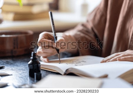 Illustrator freelancer holds fountain pen make sketch in notebook for ink in art studio. Hands artist paint on sheet papers. New designers idea for order. Hobby, interest activity for stress relieve