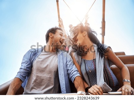 Exhilarated young couple on amusement park ride Royalty-Free Stock Photo #2328243639