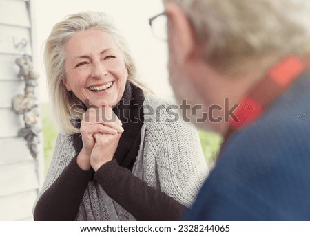 Smiling senior woman talking to man