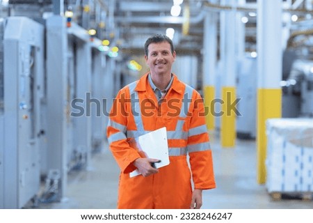 Portrait confident worker in reflective clothing clipboard in factory