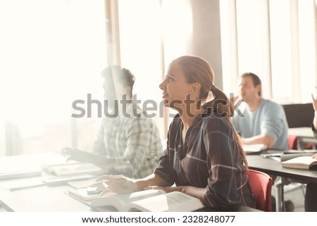 Attentive students listening in adult education classroom Royalty-Free Stock Photo #2328248077