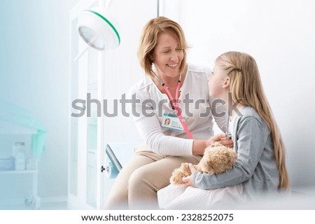 Paediatrician using stethoscope on girl patient in examination room Royalty-Free Stock Photo #2328252075
