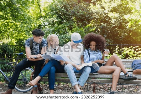 College students hanging out studying on park bench