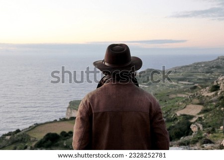 Dingli, Malta, 01-03-2012: Cliffs along the seashore near the village of Dingli, man in a wide-brimmed hat looks at the horizon, unrecognizable from behind Royalty-Free Stock Photo #2328252781