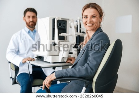 Woman happy with result after checking eyesight in ophthalmology clinic  Royalty-Free Stock Photo #2328260045