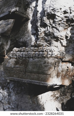 Pile of skulls and coffins are placed in caves or hanging from cliff at one of Londa tombs in Kete Kesu cultural Village. Toraja has tradition of storing corpses in caves and rock burrows. 
