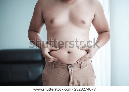 Fat man with a big belly worries about his body. Men are more likely to Clog arteries, Man at risk for diabetes, Belly Fat. Close-up part of the body Royalty-Free Stock Photo #2328274079