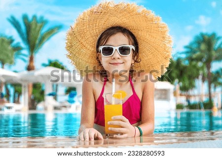 The child is drinking a cocktail by the pool. Selective focus. Kid. Royalty-Free Stock Photo #2328280593