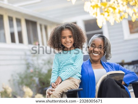 Portrait of happy grandmother and granddaughter on patio