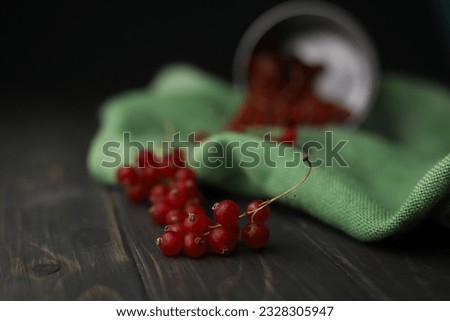 fresh summer sweet healthy red currant in a tin mug on a wooden background and with a green cloth napkin next to it. for postcards, leaflets, banners, screensavers, labels, etc.