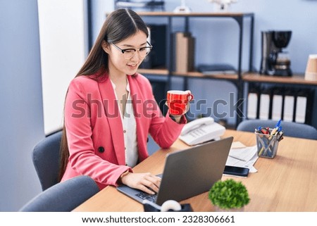 Chinese woman business worker using laptop drinking coffee at office