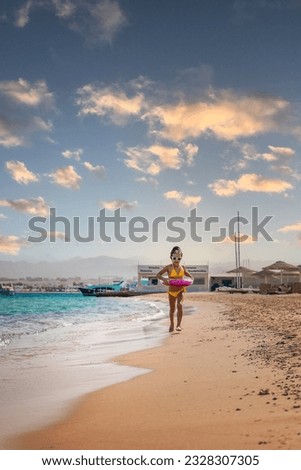 A child girl runs along the beach. Selective focus. Kid.