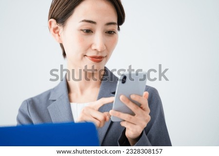 Business image of a young woman using a laptop and smartphone