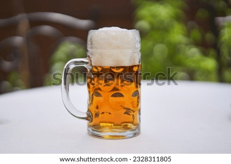 Close up picture of pint or half liter mug of czech pilsner lager beer served outside on table in beer garden during hot summer sunny day. Refreshment drink typical for beer culture of Czech republic.