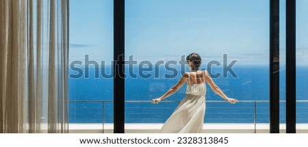 Woman looking at ocean from balcony Royalty-Free Stock Photo #2328313845
