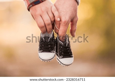 couple expecting a baby hands and his shoes Royalty-Free Stock Photo #2328316711