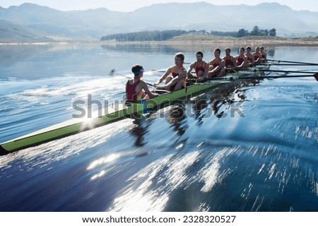 Rowing team rowing scull on lake Royalty-Free Stock Photo #2328320527
