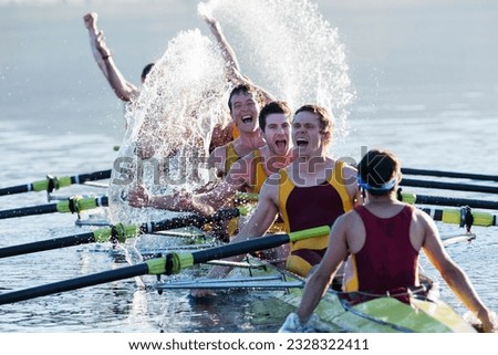 Rowing team splashing and celebrating in scull on lake Royalty-Free Stock Photo #2328322411