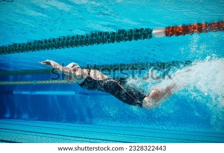Athletic competitive swimmer racing underwater Royalty-Free Stock Photo #2328322443