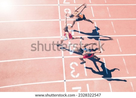 Runners crossing finish line on track Royalty-Free Stock Photo #2328322547
