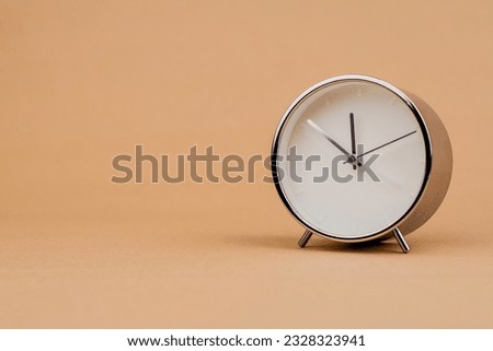 Alarm clock Beautiful modern clock lies on paper background. time clock time standstill time off work working with time  Royalty-Free Stock Photo #2328323941