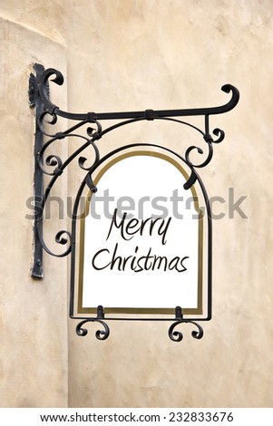 Marry Christmas on a wrought iron old sign hanging on a wall