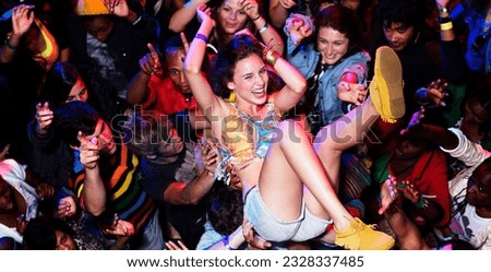 Enthusiastic woman crowd surfing at music festival Royalty-Free Stock Photo #2328337485