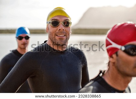 Triathletes in wetsuit smiling in water Royalty-Free Stock Photo #2328338865