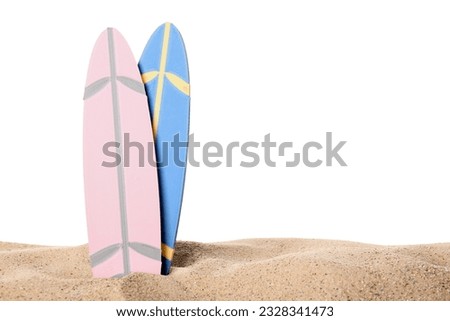 Different colorful mini surfboards on sand against white background Royalty-Free Stock Photo #2328341473