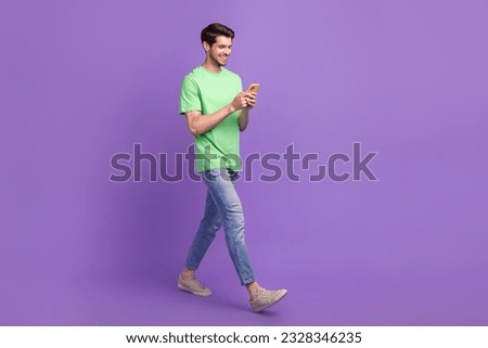 Full length size body photo of walk with smartphone funny blogger man gadget message writing chat sms isolated on purple color background
