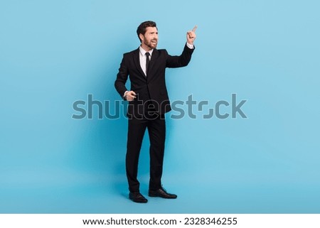Full length photo of aggressive angry boss dressed black suit screaming pointing empty space isolated blue color background Royalty-Free Stock Photo #2328346255