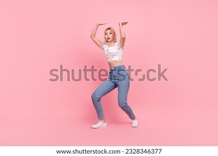 Full body length photo of young excited girl hold hard big weight empty space product pressure isolated on pastel pink color background