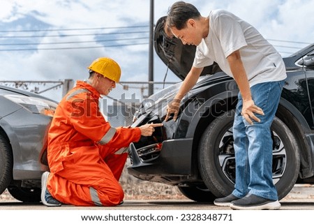 A man pointing out the scratches on his car from the car accident to the car insurance mechanic wearing yellow hardhat and orange jumpsuit or agent at the accident site Royalty-Free Stock Photo #2328348771