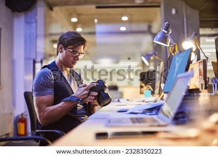 Young male photographer working in the office