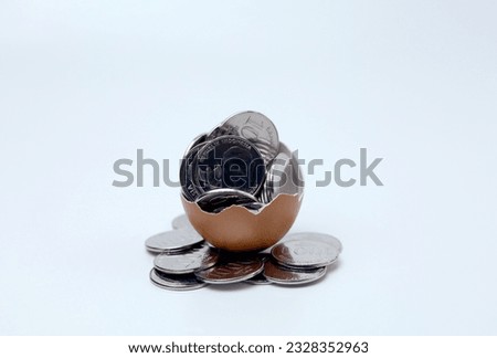 Coins inside cracked eggshell . Business concept for saving,investment, banking, finance. Indonesian coins currency.
