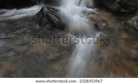 Clear water flows in a river between the rocks