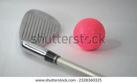 A pink golf ball ready to hit soon