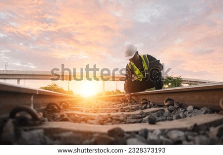 Asian engineer inspects trains Construction workers on the railway Engineer working on railway depot maintenance Royalty-Free Stock Photo #2328373193