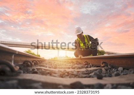 Asian engineer inspects trains Construction workers on the railway Engineer working on railway depot maintenance Royalty-Free Stock Photo #2328373195