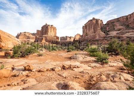 Park Avenue hiking trail through the red sandstone canyon of Arches National Park in the arid desert southwest state of Utah at sunset. Royalty-Free Stock Photo #2328375607