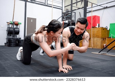 young man and woman exercising inside the gym happy smile in exercise.