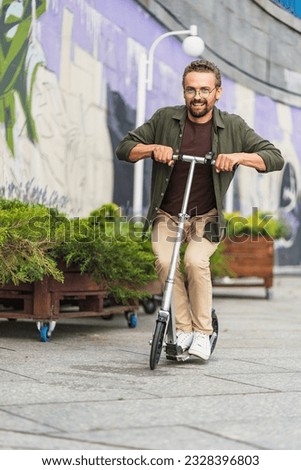Man on a scooter performing stunts with a big wheel scooter. With a handsome and confident appearance, he showcases his skills and has a blast while engaging in thrilling maneuvers. High quality photo