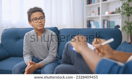 African American pre-teen boy having conversation with school psychologist, child therapy Royalty-Free Stock Photo #2328409455