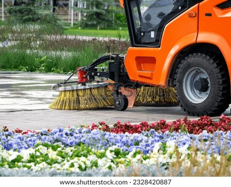 Sweeping machine brushes clean the city sidewalk. Summer city background with sweeper. Royalty-Free Stock Photo #2328420887