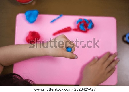Cute child's hands playing with clay