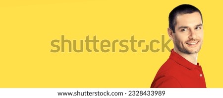 Portrait of happy smiling young man in red smart casual clothing, over yellow color background. Male handsome model at studio. Copy space empty area place for text.