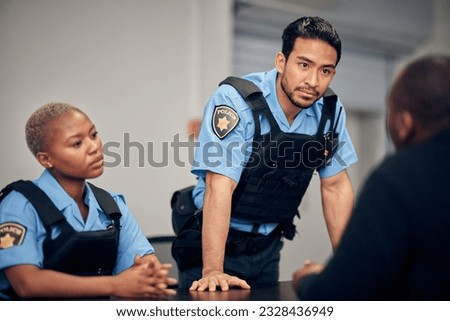 Interrogation, arrest and police team with a suspect for questions as law enforcement officers. Security, crime or investigation with a serious man and woman cop talking to a witness for information Royalty-Free Stock Photo #2328436949