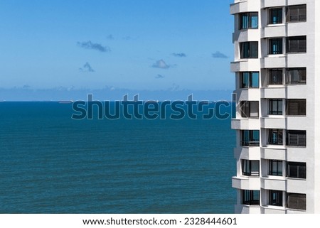 Residential building facing the sea with several ships in the background in the city of Guarujá