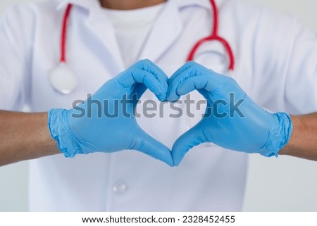 Care and health protection sign concept. Doctor's hands in protective gloves making heart.